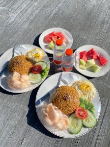 a table with four plates of food on it at KALUNA cabin in Kejajar