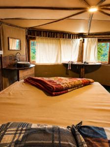 a bedroom with a large bed in a tent at Sholanest Mud House and Farm Stay in Vattavada Near Munnar in Vattavada