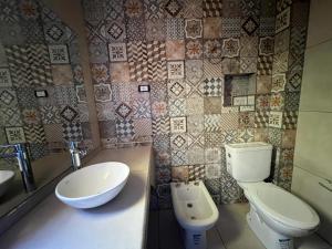 a bathroom with a toilet and a sink at HSR Termas in Termas de Río Hondo