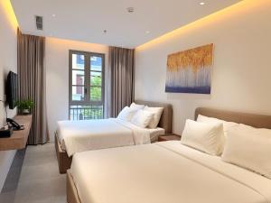 a hotel room with two beds and a window at Sunday Boutique Hotel in Phú Quốc +68 photos