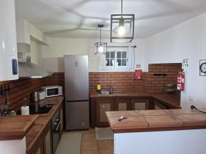 a kitchen with a refrigerator and a counter top at Pôr do Sol in Estreito da Calheta