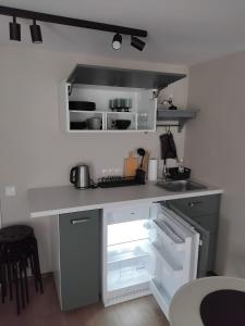 a kitchen with an open refrigerator and a sink at Viesu māja Stadula in Skrunda