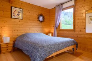 a bedroom with a bed and a window at Chalet Les Genêts 2 - Spa et Sauna in Saint-Amarin