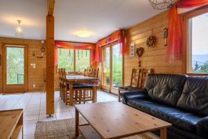 a living room with a couch and a table at Chalet Les Genêts 2 - Spa et Sauna in Saint-Amarin
