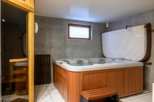 a bath tub in a bathroom with a window at Chalet Les Genêts 2 - Spa et Sauna in Saint-Amarin +27 photos