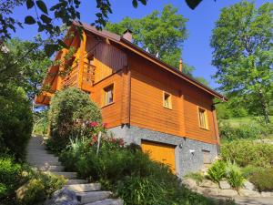 a house with an orange door and some flowers at Chalet Les Genêts 2 - Spa et Sauna in Saint-Amarin