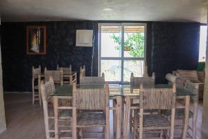 a dining room with a table and chairs and a window at Gîte Touften in Aït Aïouz +9 photos