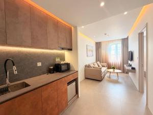 a kitchen with a sink and a living room at Sunday Boutique Hotel in Phú Quốc