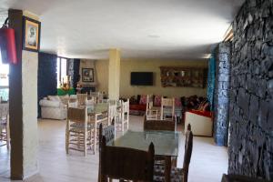 a dining room and living room with a table and chairs at Gîte Touften in Aït Aïouz