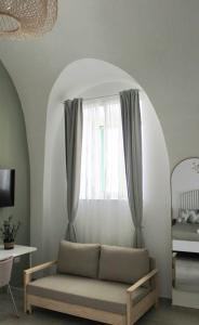a living room with a couch in front of a window at Dimora Letizia, Apulian Rooms in Sammichele di Bari