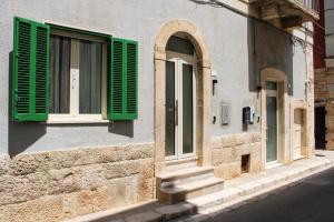 a window with green shutters on a building at Dimora Letizia, Apulian Rooms in Sammichele di Bari