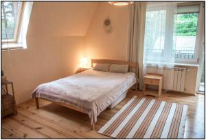 a bedroom with a bed and a large window at Mazury- dom wakacyjny in Pisz
