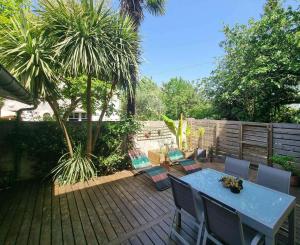 a patio with a table and chairs on a deck at Le Logis de Placide in Tarbes