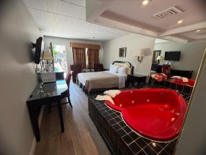 a hotel room with a red bath tub in a bedroom at Sunset Inn in Niagara Falls +73 photos