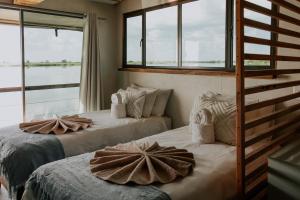 two beds in a room with windows at Muchenje River Lodge in Katima Mulilo