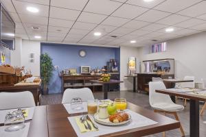 a cafeteria with a table with a plate of food on it at Appart'hôtel Odalys City - Toulouse Centre Gare in Toulouse