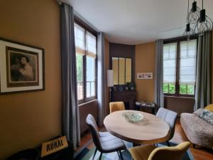 a living room with a table and chairs and a couch at Le Logis de Placide in Tarbes +19 photos