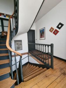 a spiral staircase in a house with art on the wall at Le Logis de Placide in Tarbes