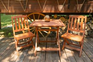 a wooden table and two chairs on a deck at Várlak Glamping in Sub Cetate