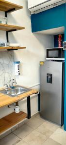a kitchen with a sink and a refrigerator at Loft #1 a una cuadra de Playa Regatas Oyster Suites in Veracruz +2 photos