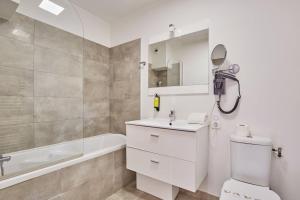 a bathroom with a toilet and a sink and a tub at Appart'hôtel Odalys City - Toulouse Centre Gare in Toulouse +103 photos