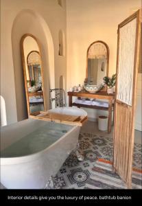a bathroom with a tub and a sink and mirrors at LoCanda - Blat in Zahlé