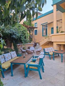 a patio with couches and tables in a courtyard at LoCanda - Blat in Zahlé