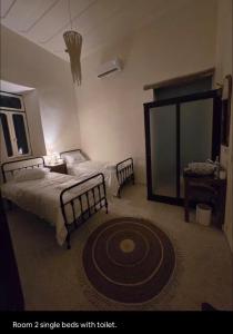 a bedroom with two beds and a large rug at LoCanda - Blat in Zahlé