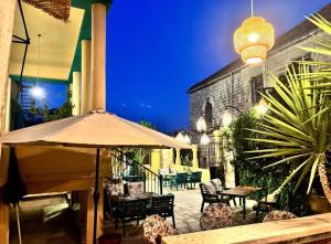 a patio with an umbrella and tables and chairs at LoCanda - Blat in Zahlé