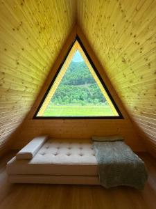 a bed in a room with a large window at LaMonte Retreat in Brezoi +27 photos
