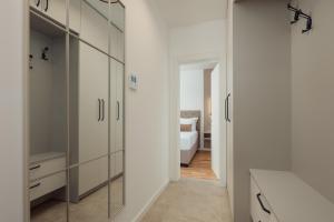 a bathroom with glass cabinets and a bedroom at Vujicic Premium Suite in Tivat +26 photos