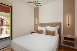 a bedroom with a white bed and a window at Vujicic Premium Suite in Tivat
