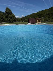 a large blue swimming pool with blue water at LaMonte Retreat in Brezoi
