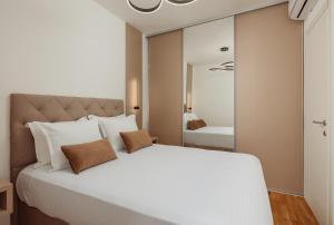 a bedroom with a large white bed and a mirror at Vujicic Premium Suite in Tivat