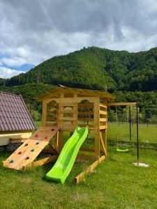 a playground with a slide and a play house at LaMonte Retreat in Brezoi