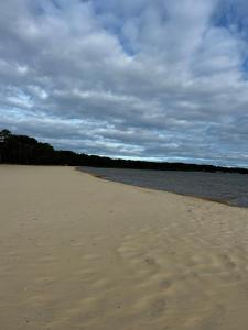 a beach with sand and water on a cloudy day at Chalet à Biscarrosse in Biscarrosse +2 photos