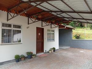 a house with awning and a porch with potted plants at Casa Zibell centro de Pomerode in Pomerode