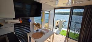a living room with a table and a large window at Houseboat Bella in Tereszewo