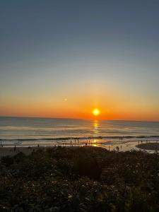 a sunset at the beach with people on the beach at Chalet à Biscarrosse in Biscarrosse