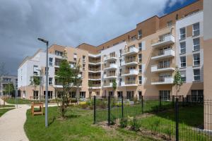 an apartment building with a fence in front of it at DOMITYS - L'Edito in Amiens