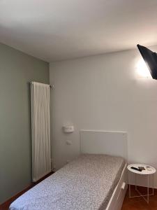 a small bedroom with a bed and a radiator at Affittacamere Cà Bianca in Casa Rossa