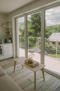 a living room with a table and a large window at Well M cottage in Velem