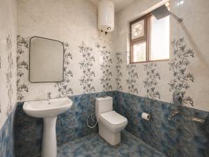 a bathroom with a sink and a toilet and a mirror at The Sanctuary in McLeod Ganj