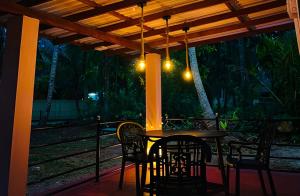 a table and chairs on a porch at night at Aqua Bliss Resort & Villa Bentota in Bentota