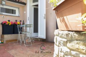 a patio with a table and chairs in front of a door at Il Gioiello di Frieda - in centro a Muggia in Muggia