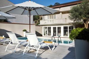 un grupo de sillas y una sombrilla junto a una piscina en Lemon House, en Savoca