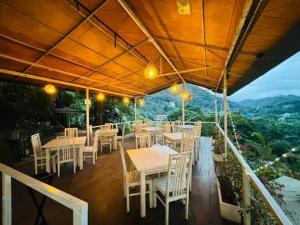 a restaurant with tables and chairs on a balcony at Kzea's Inn in Kidapawan