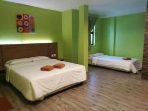 two beds in a room with green walls at Kzea's Inn in Kidapawan