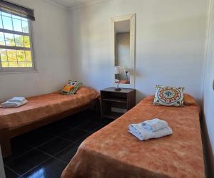 a room with two beds and a mirror at Departamento en San Juan Capital 3 dormitorios hasta 6 personas in San Juan