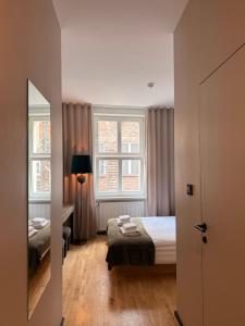 a small room with a bed and two windows at Kamea in Poznań